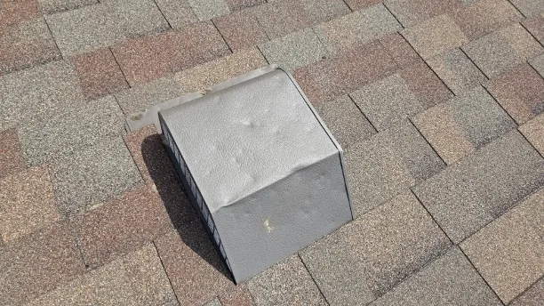 Dented roof vent and flashing from hail impact. Insurance-documentable damage